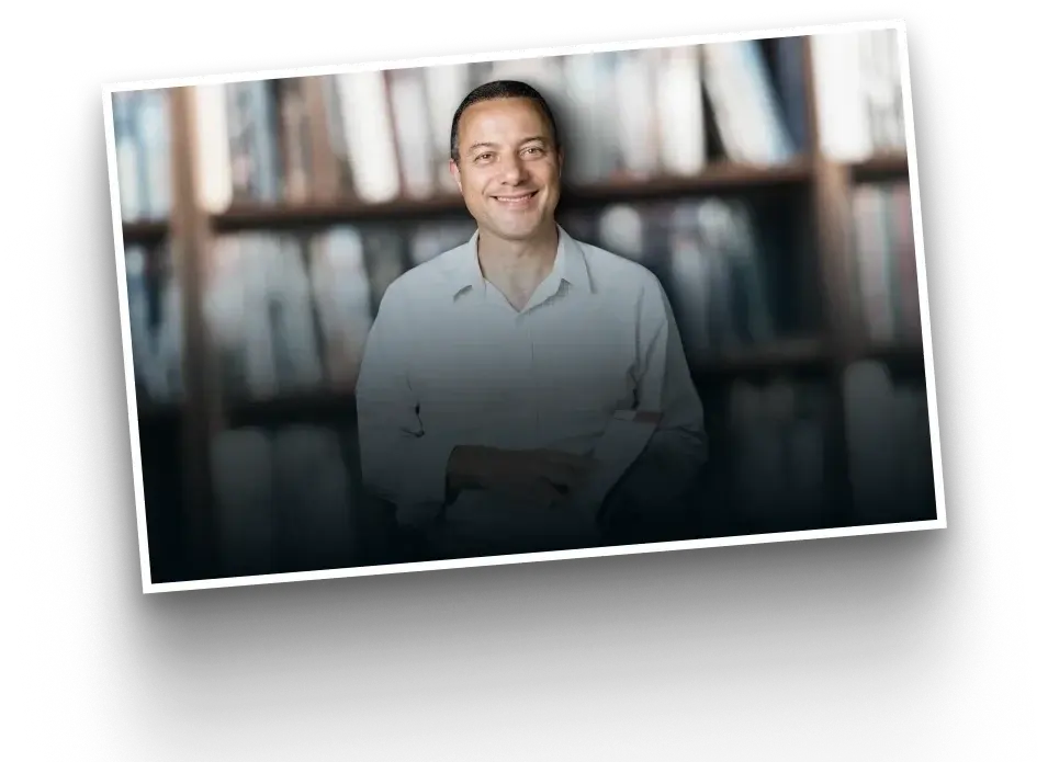 Professor Josué Alves em frente a uma estante de livros